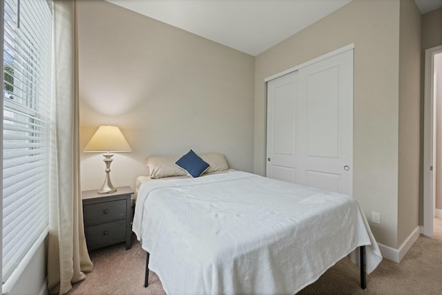 bedroom featuring a closet and light colored carpet