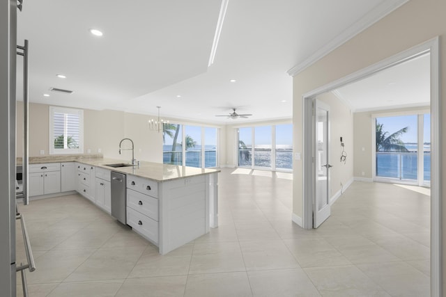 kitchen with dishwasher, ceiling fan with notable chandelier, a water view, sink, and white cabinetry