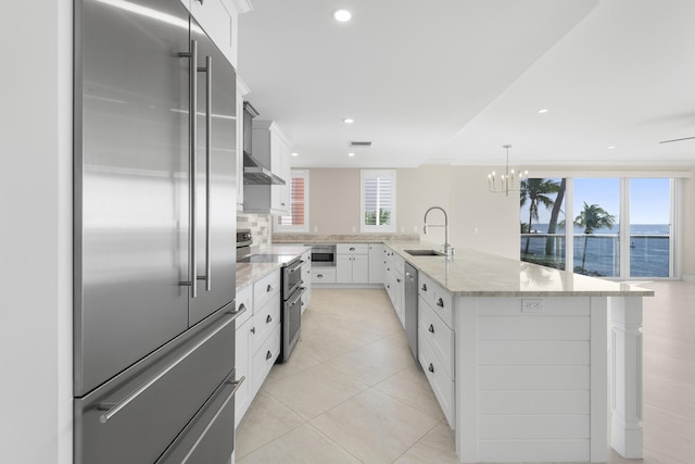 kitchen with white cabinets, sink, a kitchen island with sink, and appliances with stainless steel finishes