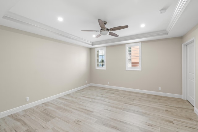 interior space with ceiling fan, a raised ceiling, light wood-type flooring, and crown molding