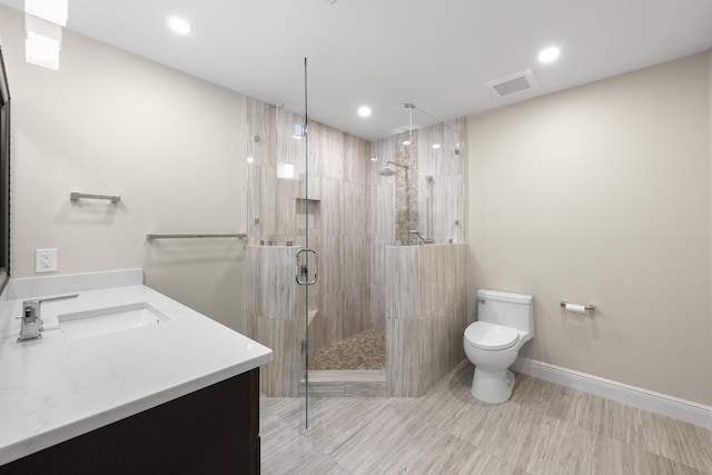 bathroom featuring vanity, toilet, and an enclosed shower