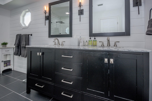 bathroom with tile patterned flooring, vanity, and walk in shower