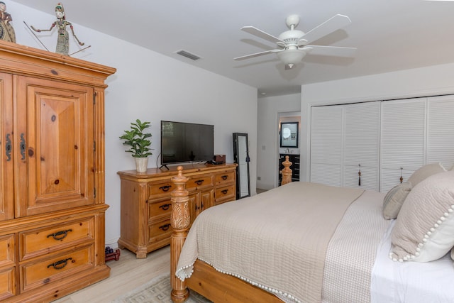 bedroom with light wood finished floors, a closet, visible vents, and ceiling fan