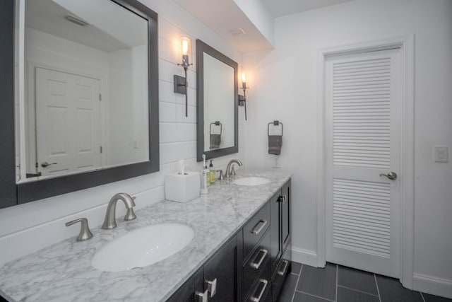 full bath featuring double vanity, tile patterned floors, visible vents, and a sink