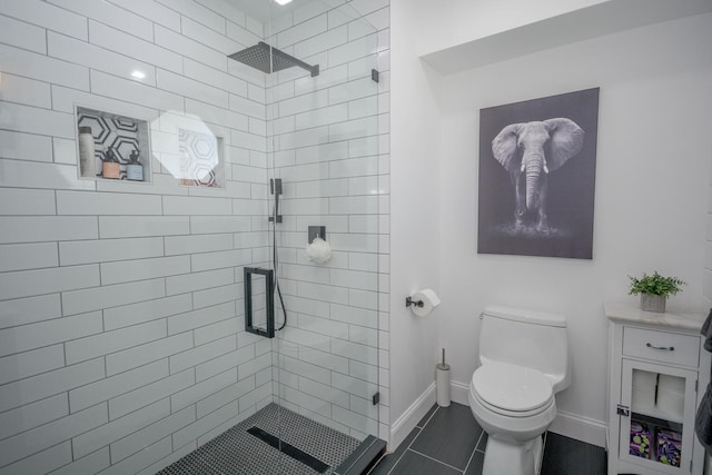 bathroom featuring toilet, baseboards, and a shower stall