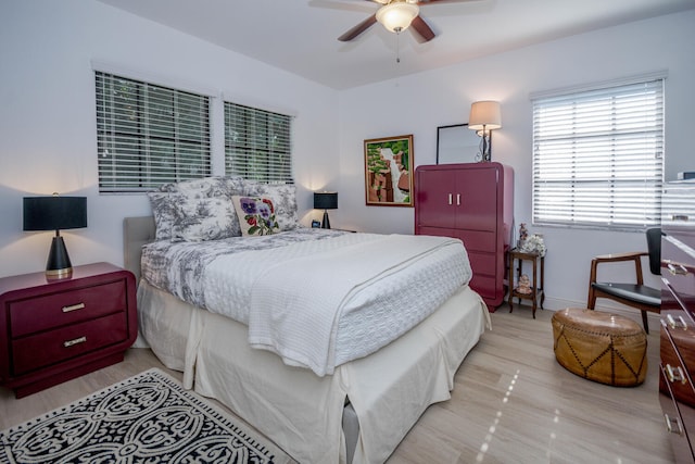 bedroom with ceiling fan, baseboards, and wood finished floors