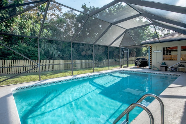 view of pool with a lawn, a fenced in pool, a patio, glass enclosure, and a fenced backyard