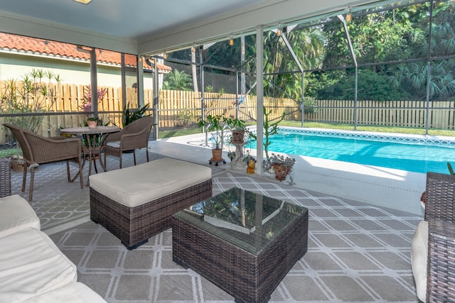 view of pool with glass enclosure and a patio area