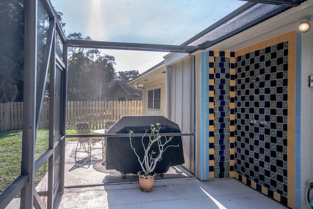 view of patio featuring a grill and fence