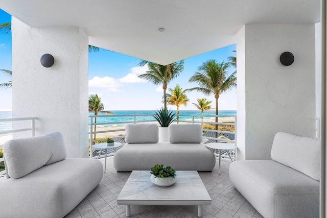 view of patio with a view of the beach, a water view, and a balcony