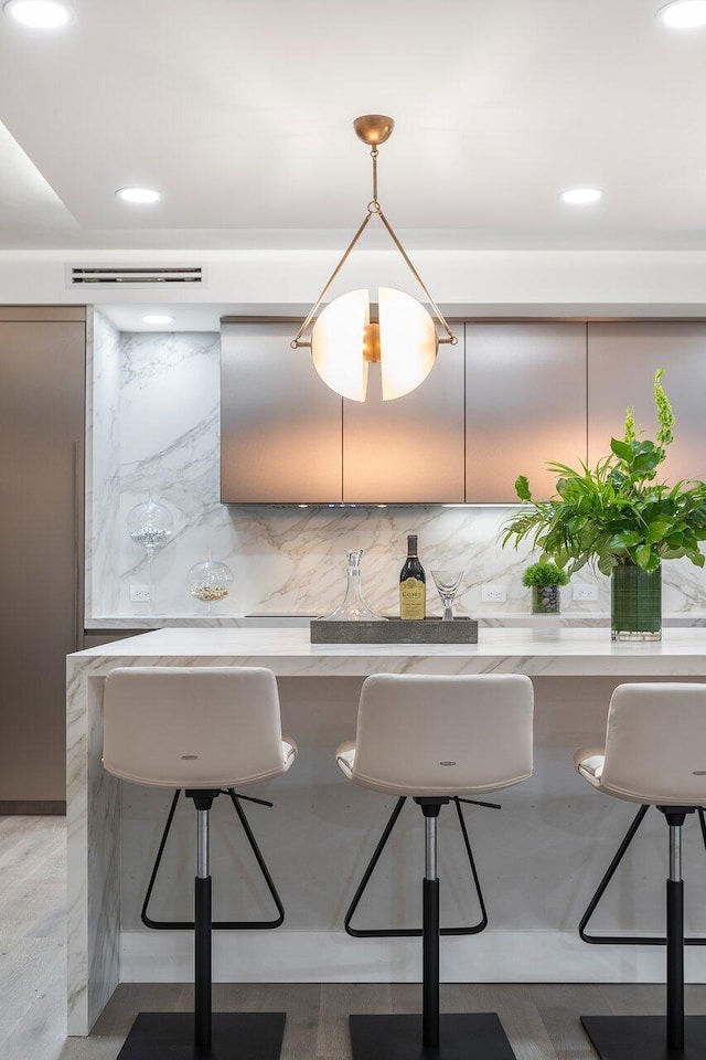 kitchen with a breakfast bar area, tasteful backsplash, and hardwood / wood-style floors