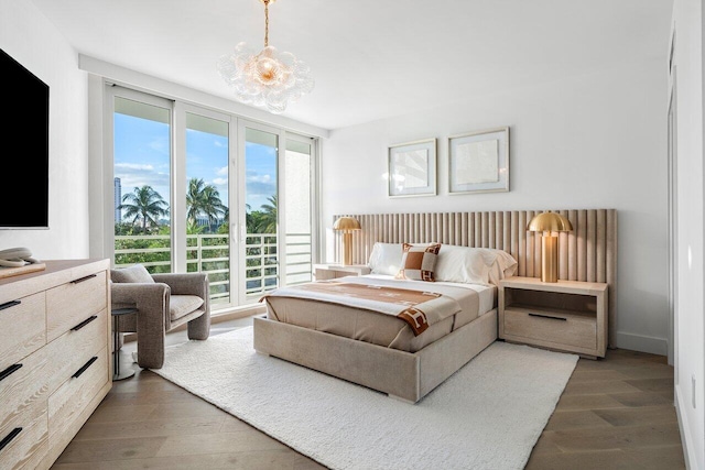 bedroom with a notable chandelier and dark hardwood / wood-style floors