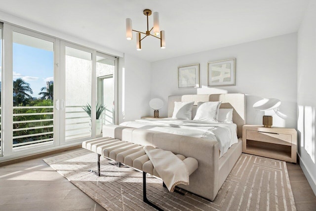 bedroom with access to exterior, an inviting chandelier, and light wood-type flooring