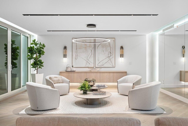 sitting room featuring a wall of windows and hardwood / wood-style flooring