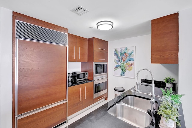 kitchen featuring built in appliances and sink