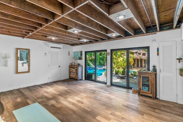 basement featuring wood-type flooring and an AC wall unit