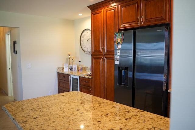 kitchen with kitchen peninsula, tile patterned floors, light stone counters, fridge with ice dispenser, and wine cooler