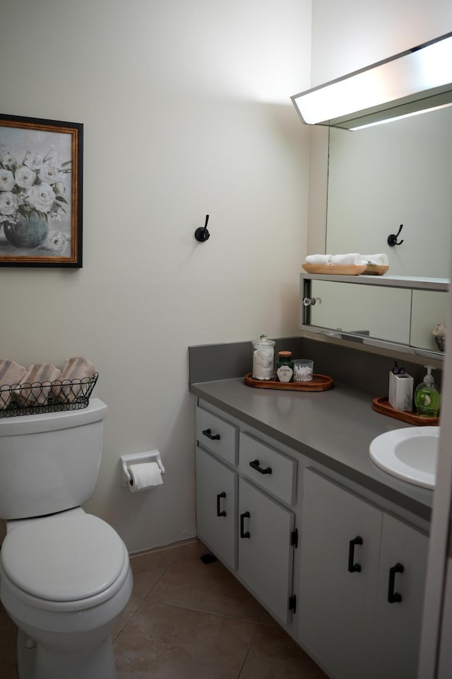 bathroom with tile patterned flooring, vanity, and toilet