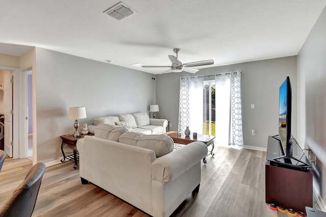 living room featuring ceiling fan and light hardwood / wood-style flooring