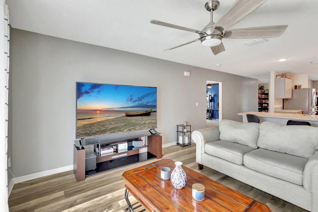 living room featuring ceiling fan and light hardwood / wood-style flooring