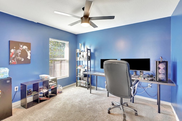 carpeted home office featuring ceiling fan