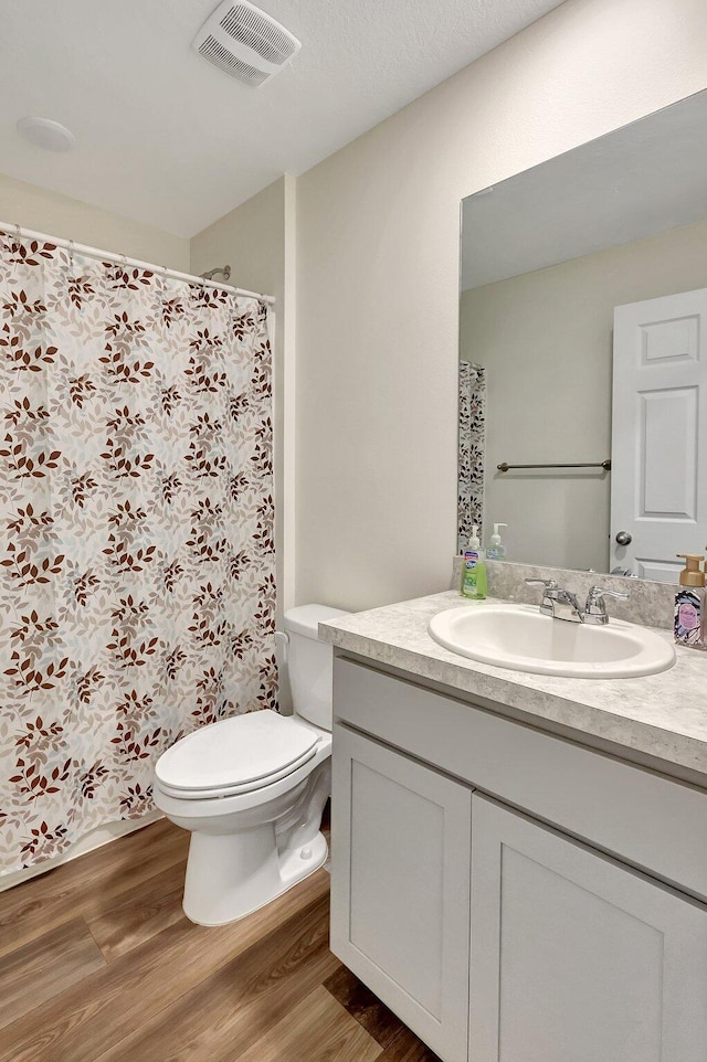 bathroom featuring wood-type flooring, vanity, and toilet