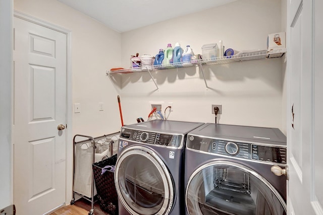 laundry room with separate washer and dryer and light hardwood / wood-style flooring