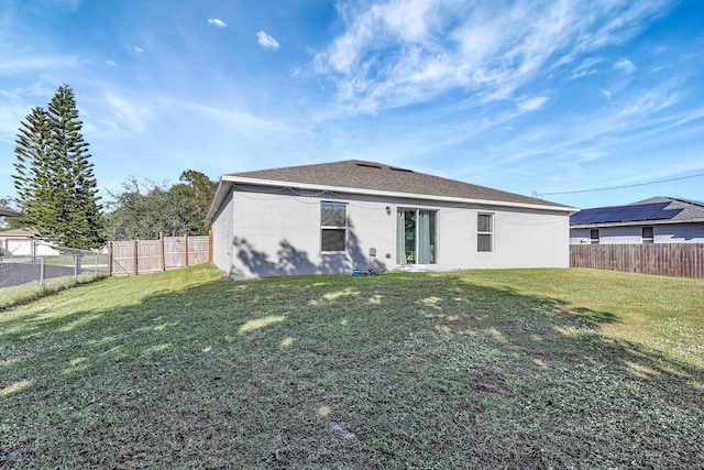 rear view of house featuring a yard