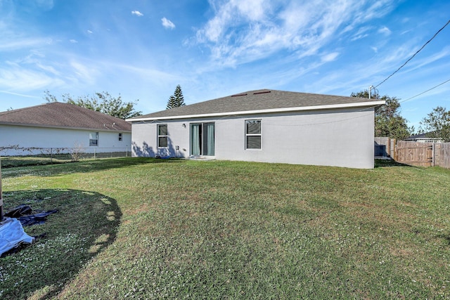 rear view of house with a yard