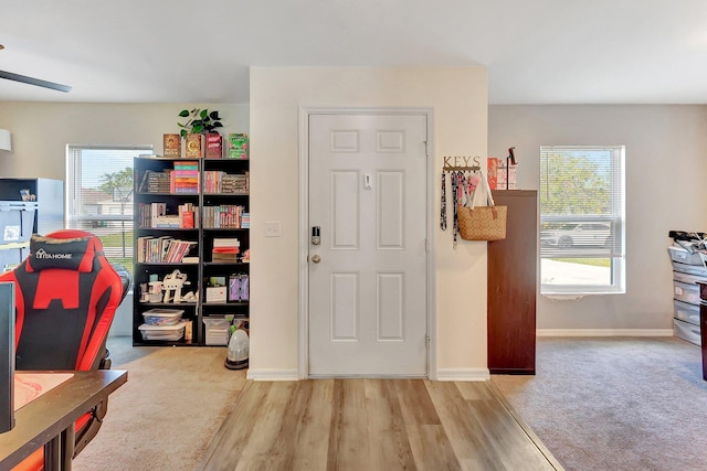 carpeted foyer featuring ceiling fan