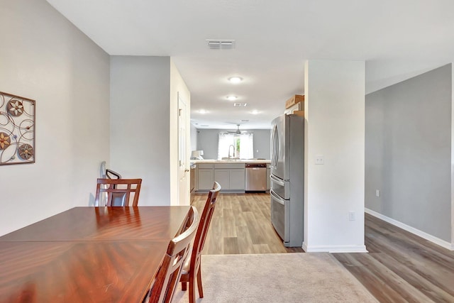 dining area with sink and light wood-type flooring