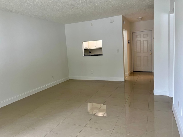 unfurnished room featuring a textured ceiling