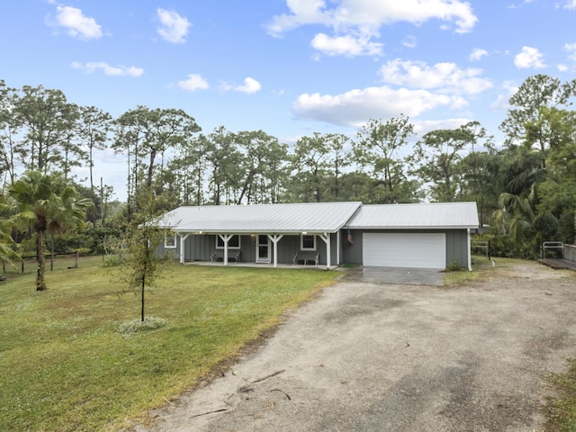 single story home with a porch, a garage, and a front lawn