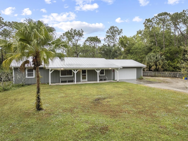 single story home featuring a porch, a garage, and a front lawn