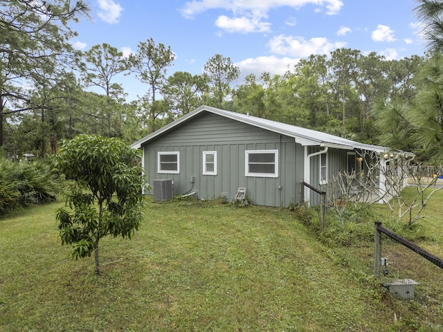 view of side of property with central AC and a lawn