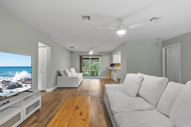 living room featuring ceiling fan and hardwood / wood-style flooring