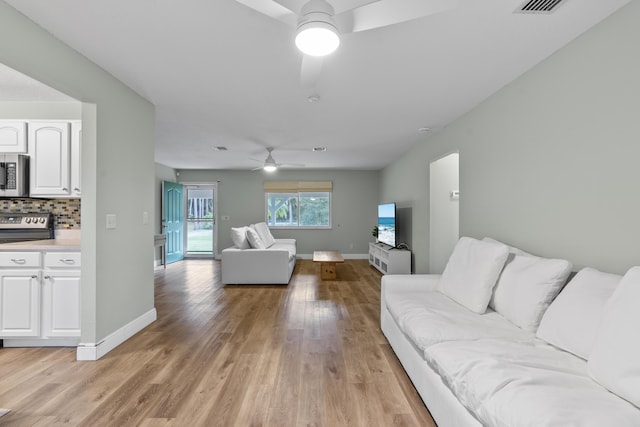 living room featuring light hardwood / wood-style flooring and ceiling fan