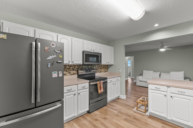 kitchen with decorative backsplash, appliances with stainless steel finishes, a textured ceiling, ceiling fan, and white cabinetry