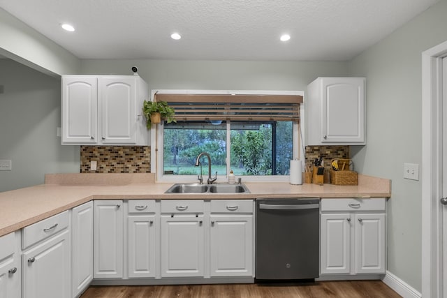 kitchen featuring stainless steel dishwasher, decorative backsplash, white cabinetry, and sink