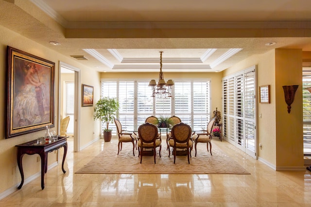 dining area featuring a notable chandelier, crown molding, and a tray ceiling