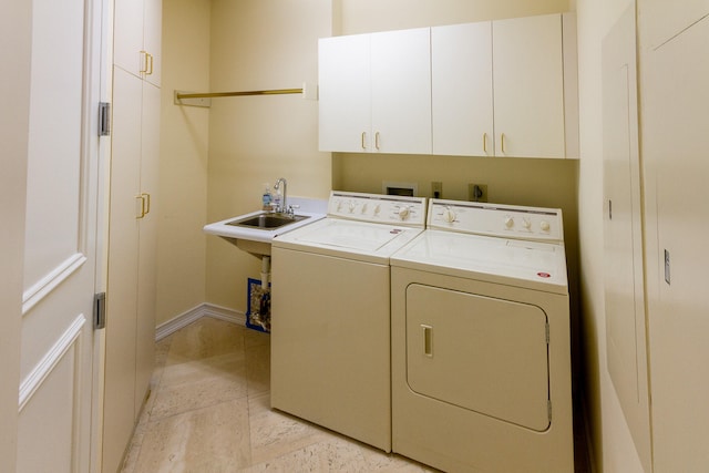 clothes washing area featuring cabinets, sink, and washing machine and clothes dryer