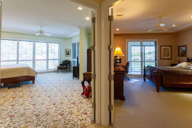 carpeted bedroom featuring decorative columns, ceiling fan, and ornamental molding