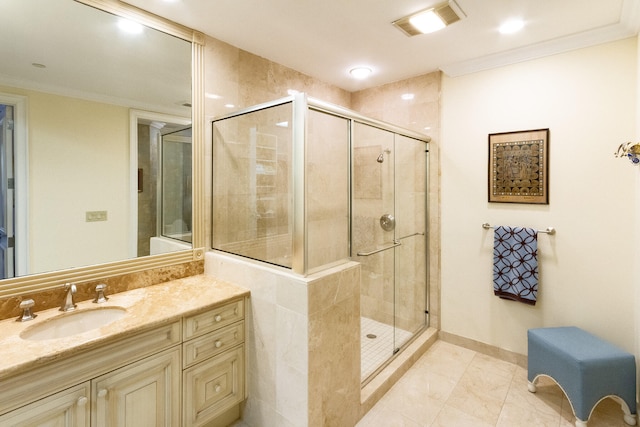 bathroom featuring vanity, a shower with shower door, and crown molding