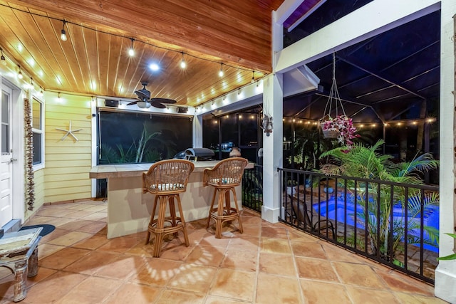 view of patio with ceiling fan and an outdoor bar