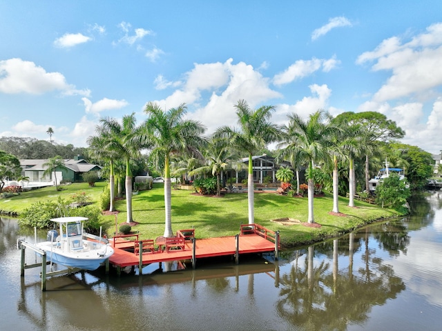 view of dock with a yard and a water view