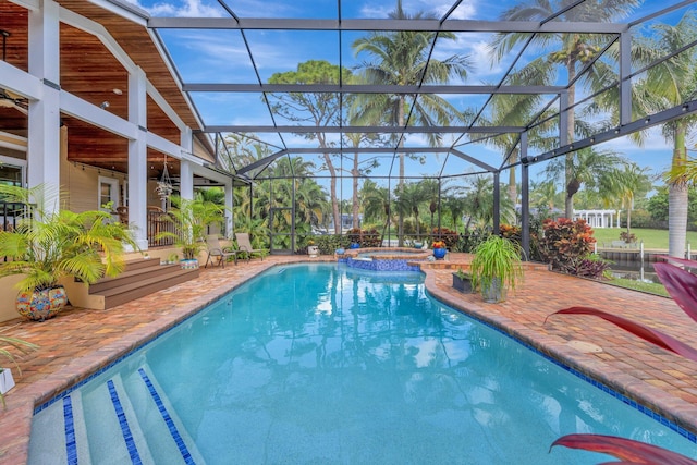 view of swimming pool with ceiling fan, a patio area, a lanai, and an in ground hot tub