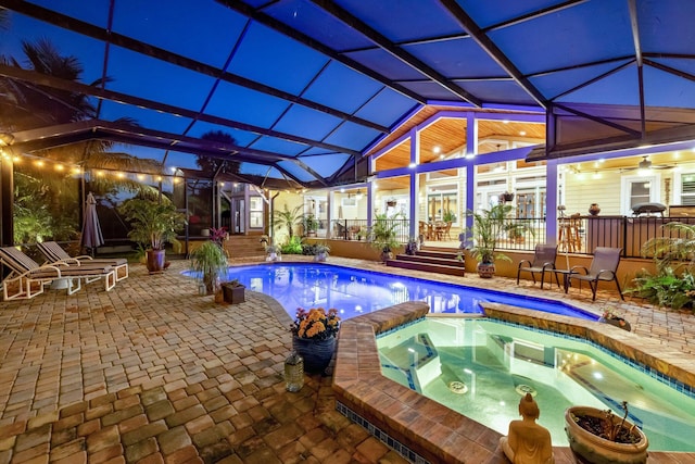 view of swimming pool featuring an in ground hot tub, a patio, and glass enclosure