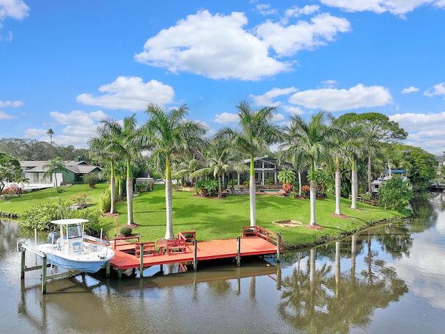 view of dock with a yard and a water view