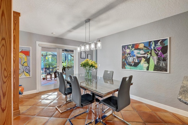 dining room with light tile patterned floors, a textured ceiling, and french doors