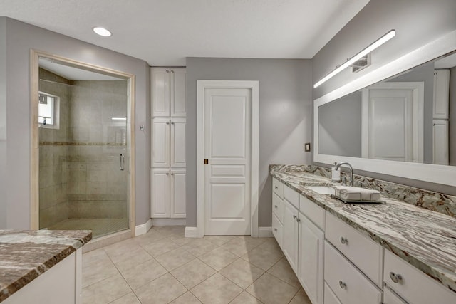 bathroom featuring tile patterned flooring, vanity, and walk in shower